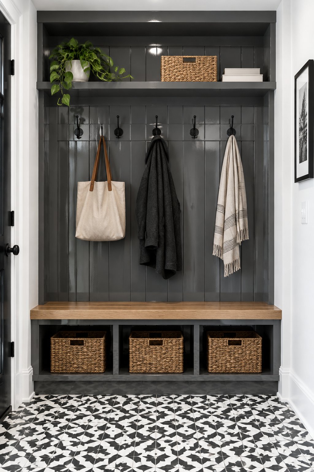 A mudroom with paneled walls, overhead storage, white trim, and patterned floor tiles.